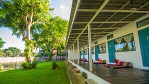 Un espace extérieur abrité comprenant une piscine, des bancs et des plantes en pot.