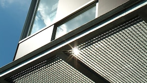 Un bâtiment moderne doté de grandes fenêtres et d’une façade métallique.