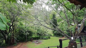 A lush garden with a stone pathway leading to a gazebo. - Sabi Star Chalets (Sabie)