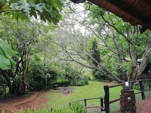 Un exuberante jardín con un sendero de piedra que lleva a un pabellón.