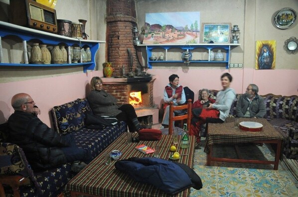 A cozy living room with a brick fireplace, sofas, and a coffee table.
