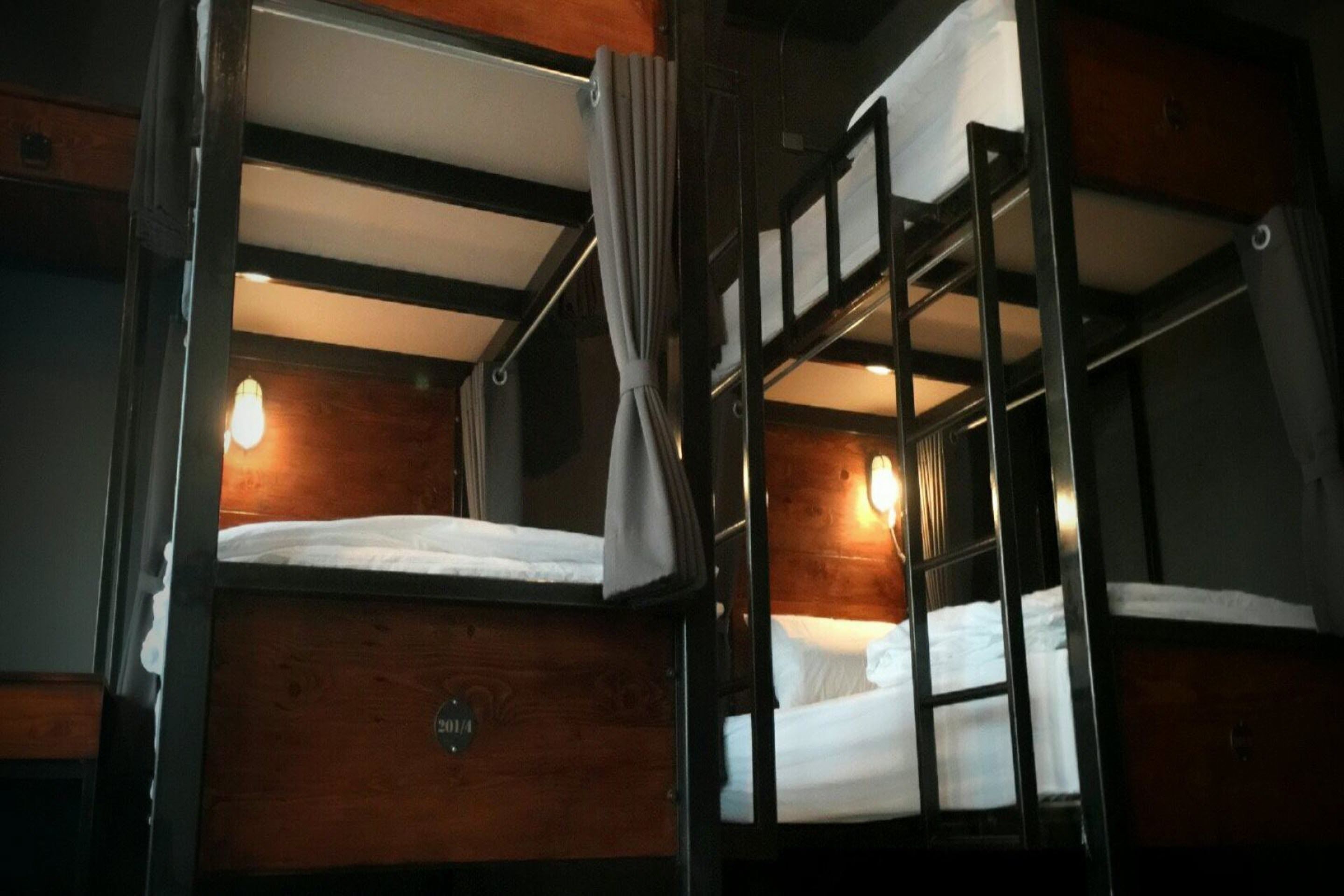 A bunk bed room with wooden walls and a metal ladder.