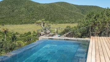 Outdoor pool, an infinity pool, pool umbrellas, sun loungers