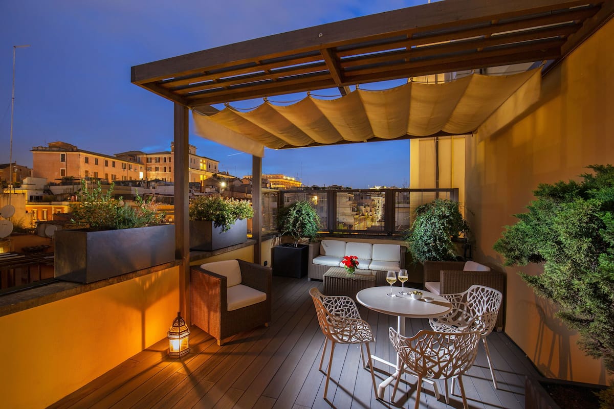 Une terrasse extérieure avec des sièges, une pergola et des plantes en pot.