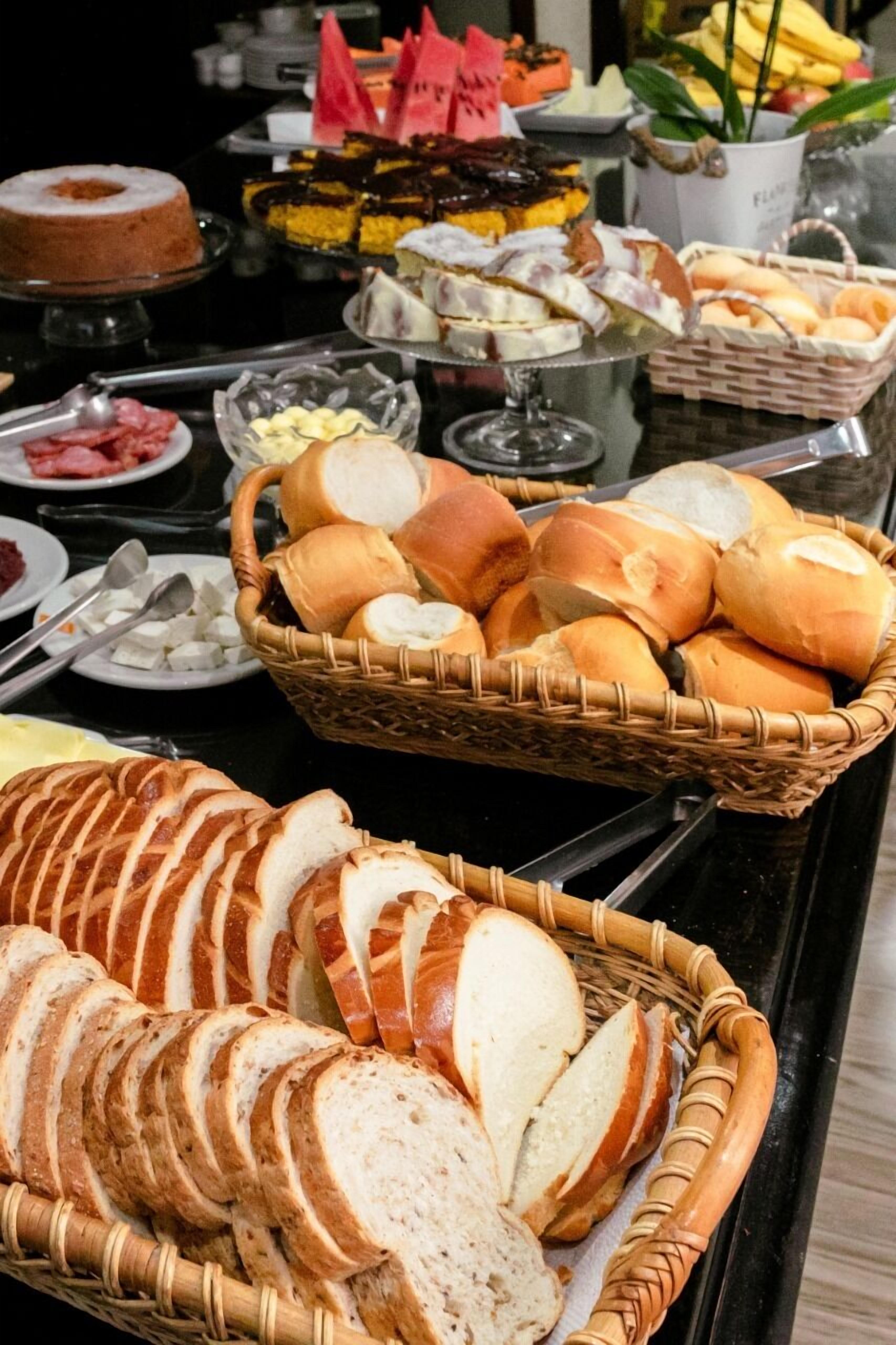 Un buffet proposant une variété de pains, de viennoiseries et de desserts.