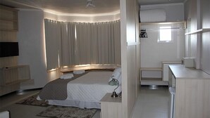 A modern bedroom with a large bed, bedside tables, a desk, and a television. - Hotel Bell Sttar (Marau)