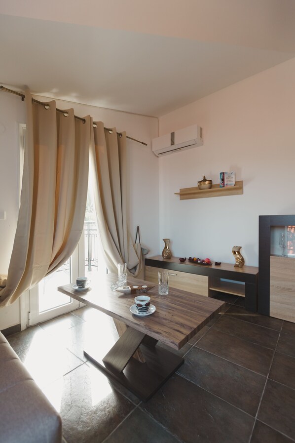 A modern living room with a wooden dining table, a sofa, and a fireplace.