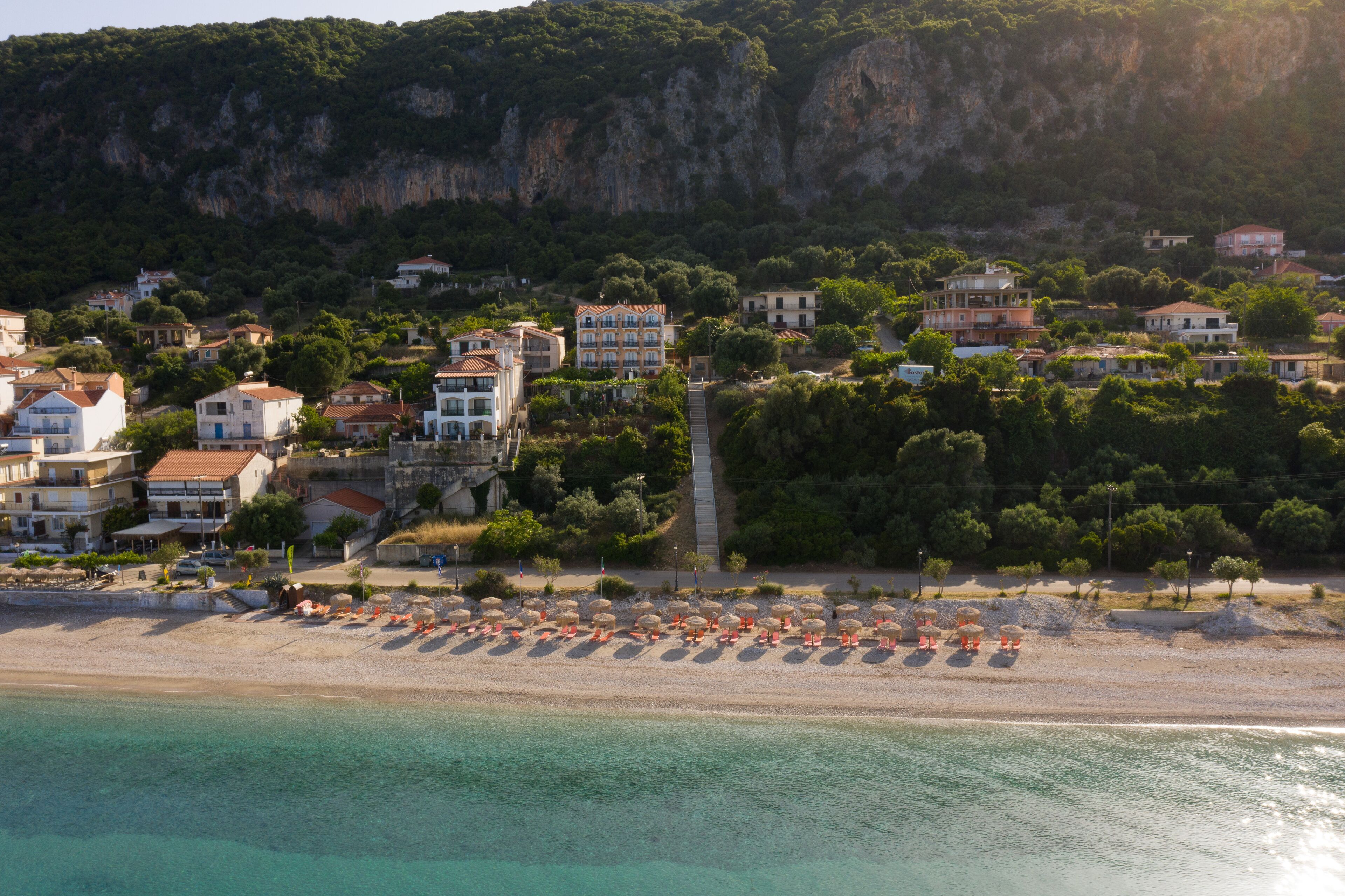 A coastal town with a beach, buildings, and a cliff.