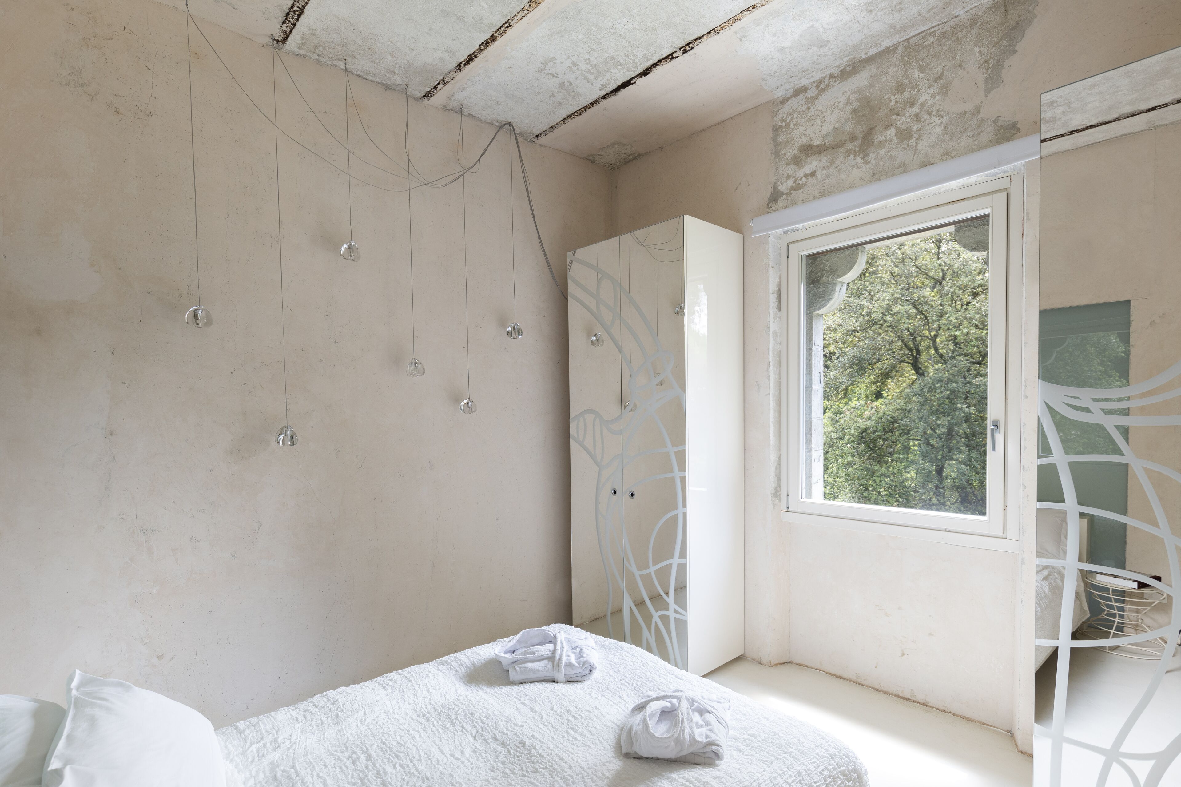 A bedroom with a bed, a window, and a wardrobe.