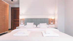A hotel room with a large bed, two bedside tables, a wooden wardrobe, and a grey headboard. - Fortune Boutique Old Town (Poznan)