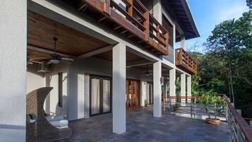 A modern building with a spacious patio area, large windows, and a wooden balcony.
