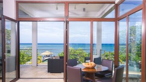 A balcony with a table, chairs, and a bowl of fruit. - Xbalanque (Roatan)