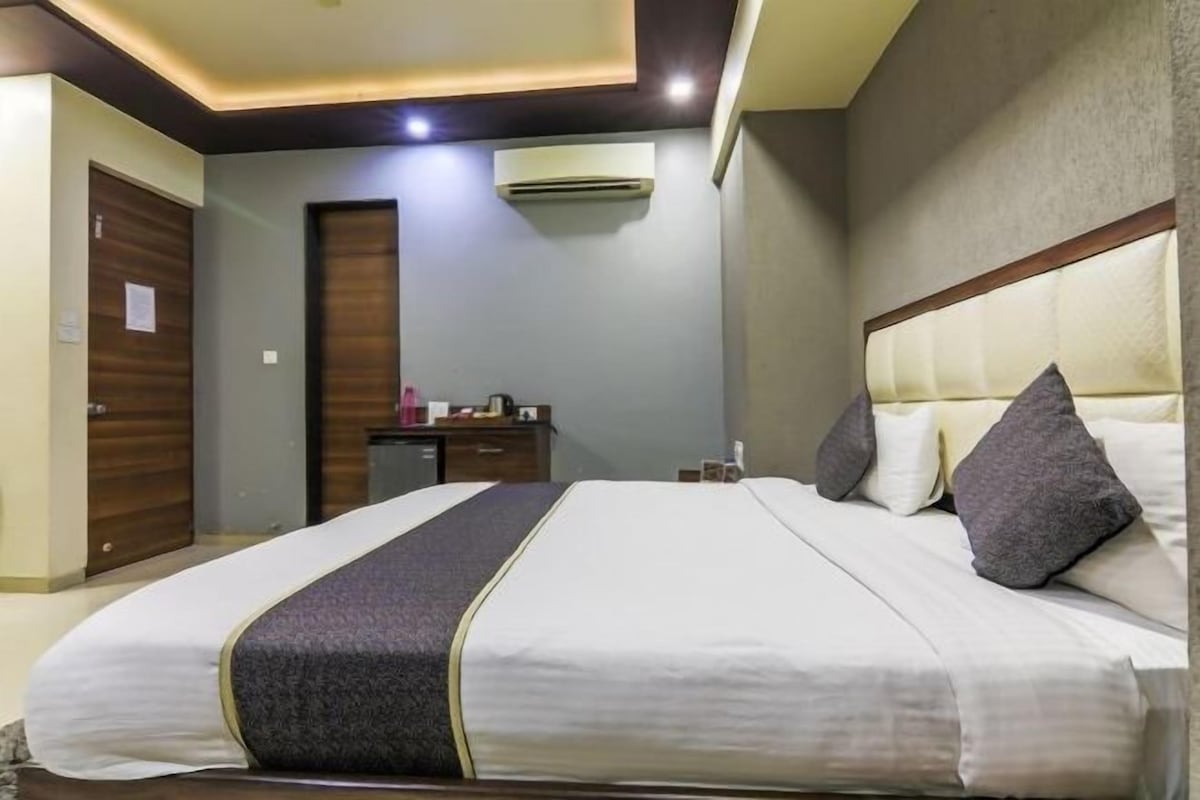 Une chambre d’hôtel équipée d’un lit, d’une table de chevet et d’un appareil de climatisation.
