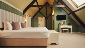 A bedroom with a large bed, a desk, a chair, and a television. - Rose & Crown (Plymouth)