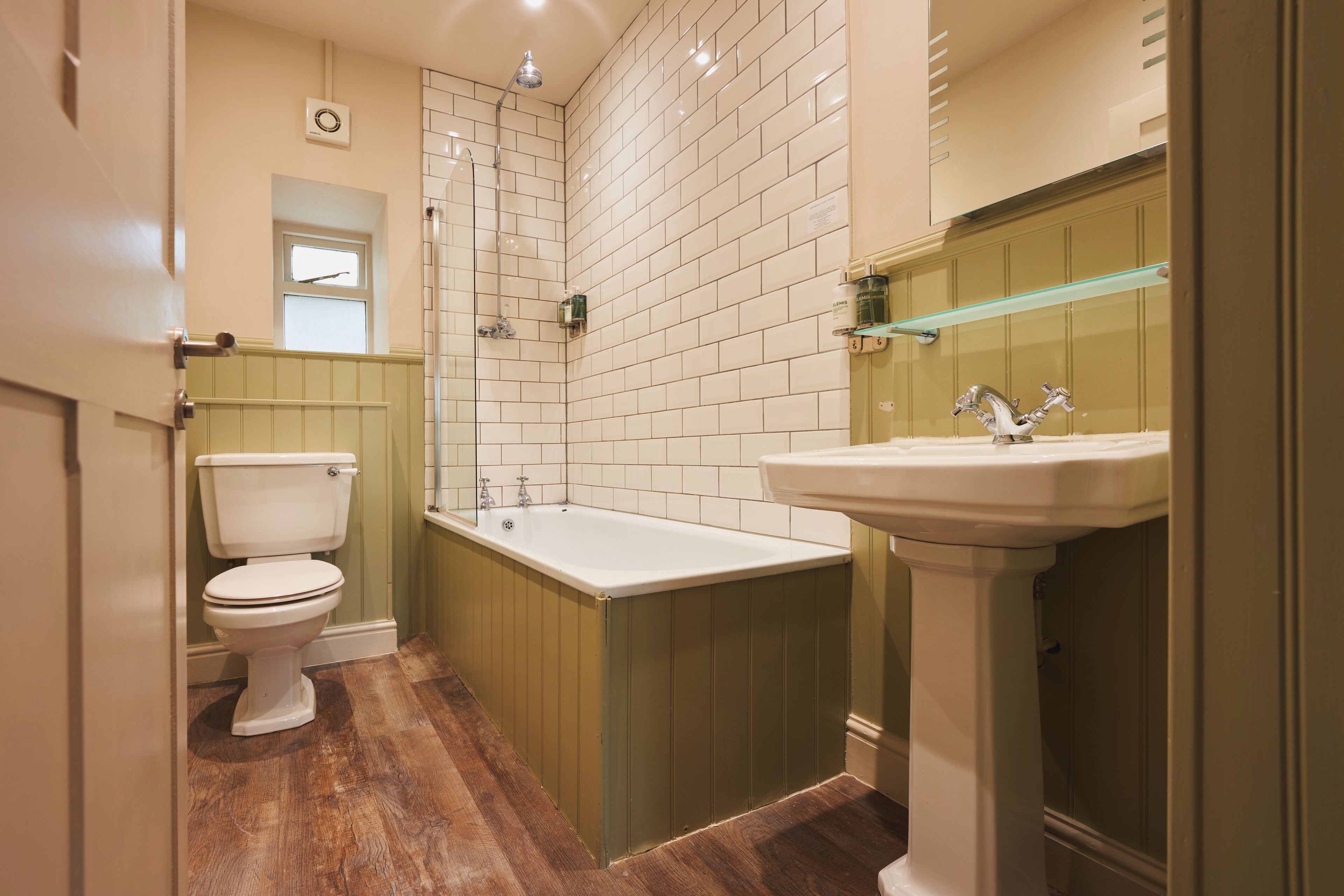 A bathroom with a toilet, bathtub, and sink.