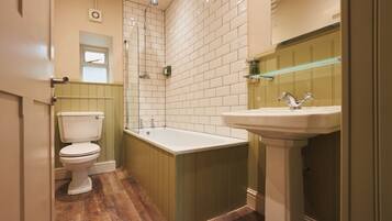 A bathroom with a toilet, bathtub, and sink.