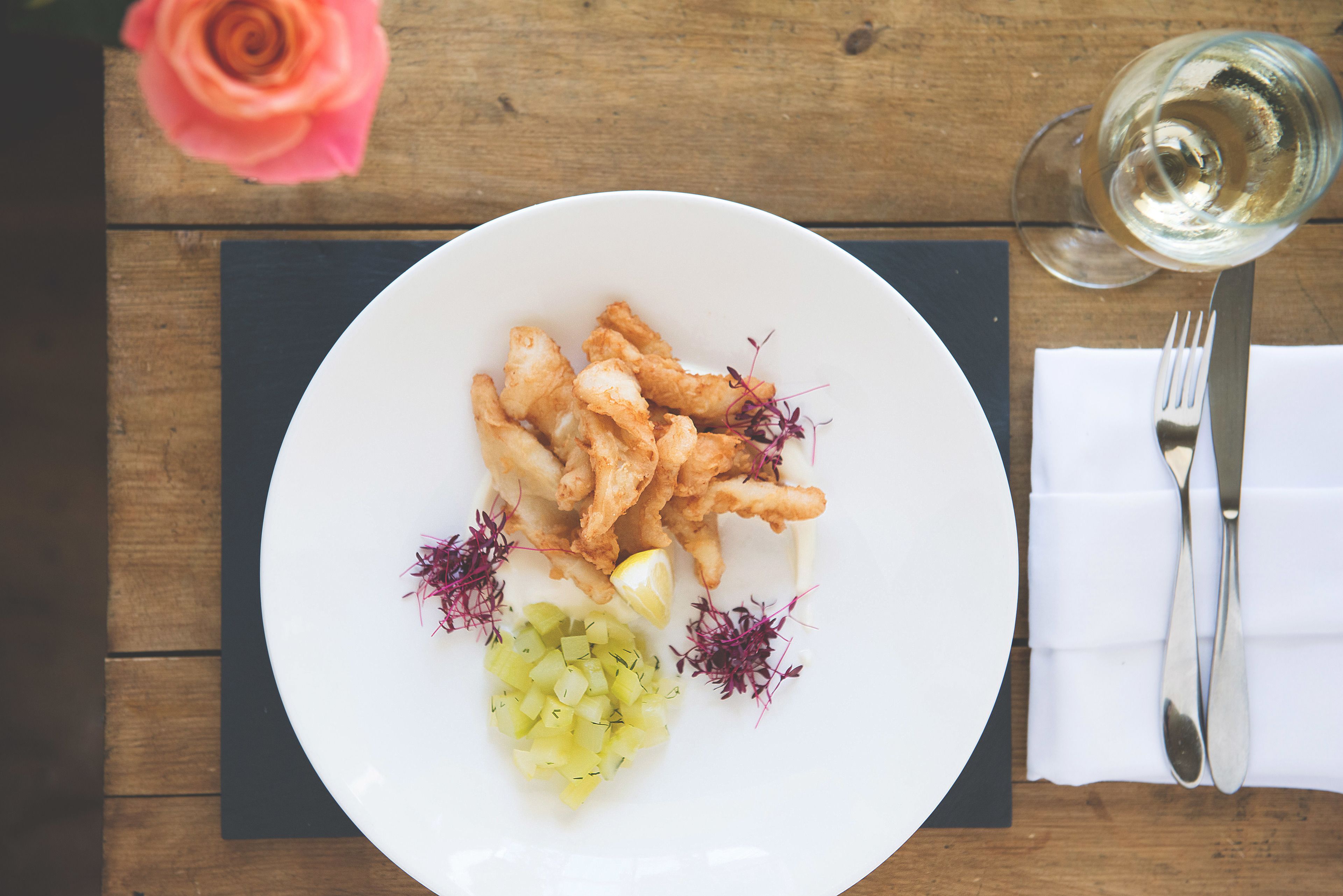 A plate of food with a fork and knife on a wooden table.