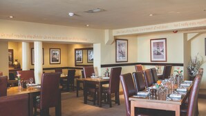 A restaurant with multiple dining tables and chairs, framed pictures on the walls, and a carpeted floor. - Rose & Crown (Plymouth)