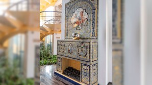 Una chimenea con diseños intrincados, una escalera de caracol y vistas a plantas de interior.