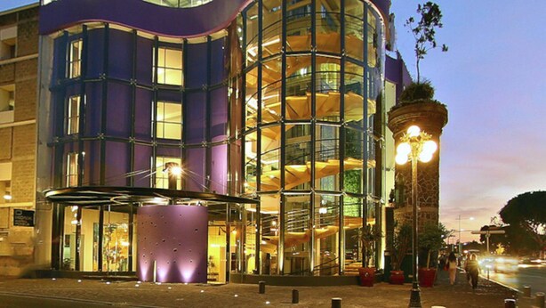 Un edificio moderno con fachada de vidrio y un letrero que dice "IKONIK".