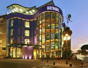 A modern building with a glass facade and a sign reading "IKONIK". - Ikonik Hotel Puebla (Puebla)