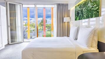 Een hotelkamer met een groot bed, uitzicht naar buiten en een schuifdeur.