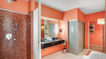 A modern bathroom with a tiled shower, a double sink vanity, and a large mirror.