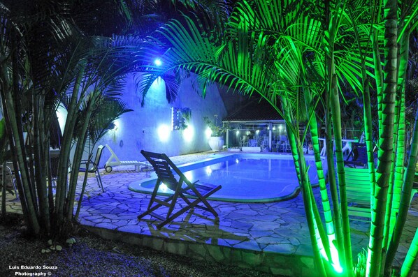 Una piscina al aire libre, sillones reclinables de piscina