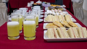 A conference room with a long table set for a meeting, equipped with a projector screen, and surrounded by attendees. - YOURS HOTEL LIFESTYLE (Chiclayo)