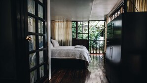 A bedroom with a bed, a wardrobe, and a window with curtains. - Gringo Bill's Boutique Hotel (Machu Picchu)