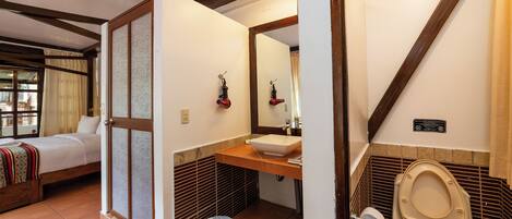 A bathroom with a toilet, sink, and mirror.