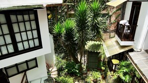 A residential courtyard with a swimming pool, lush greenery, and a multi-story building with balconies. - Gringo Bill's Boutique Hotel (Machu Picchu)
