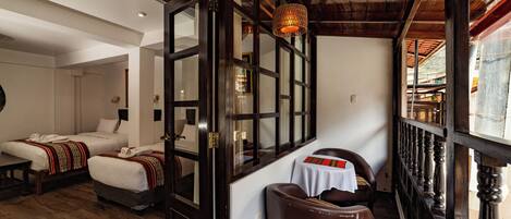Une chambre d’hôtel avec deux lits, un plafond en bois, une grande fenêtre et une vue sur l’extérieur.