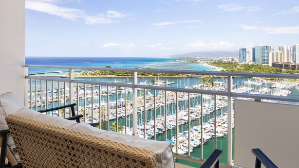 A balcony with a view of a marina and cityscape. - Ilikai Lite (Honolulu)