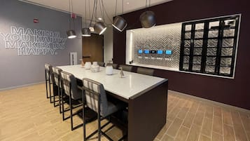 Un comedor moderno con una isla central, sillas, luces colgantes y una pared decorativa con una cita inspiradora.