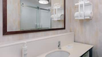 Un bany amb un mirall gran, un lavabo i dues barra de tovalloles.