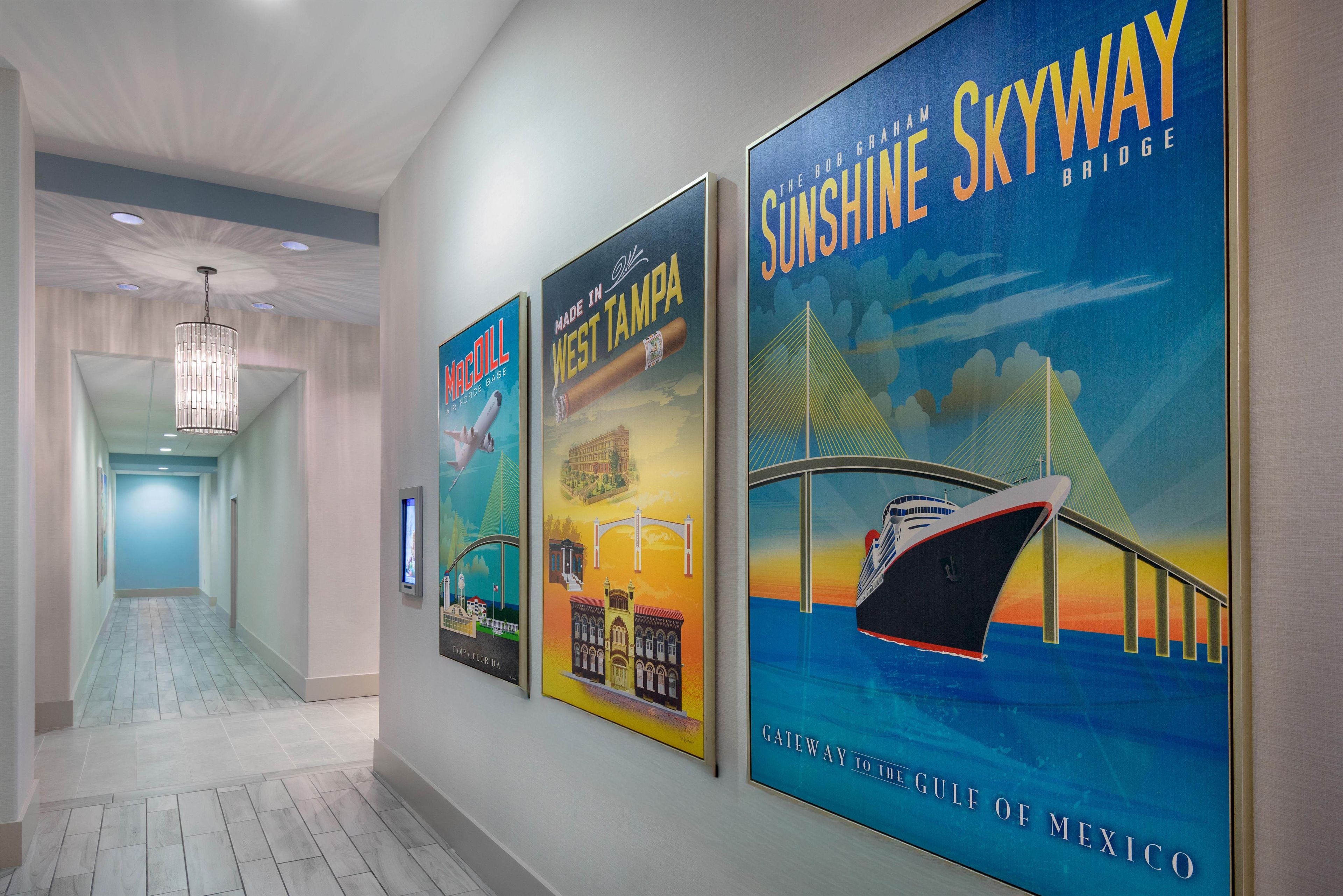 A hallway with three large posters on the wall, each depicting different landmarks and attractions.