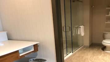 A modern bathroom with a glass-enclosed shower, a white sink, and a toilet.