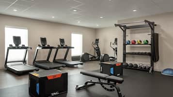 A gym with treadmills, weight machines, and a squat rack.