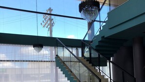 A modern interior with a staircase, two sofas, and a round rug. - Villa Premium Hotel (Erechim)