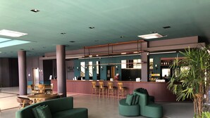 A modern hotel lobby with a bar area, seating arrangements, and a large potted plant. - Villa Premium Hotel (Erechim)