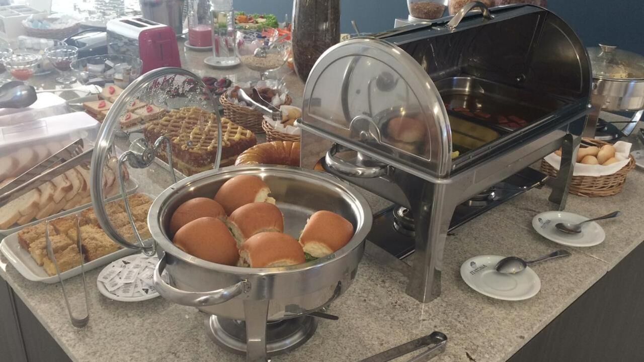 Un montaje de buffet con diferentes opciones de comida, incluyendo sándwiches, gofres y una estación de comidas calientes.