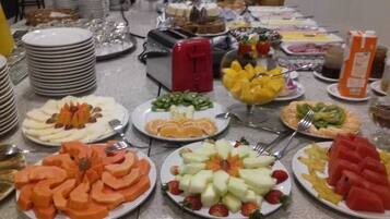 Una mesa de buffet con diversas opciones de fruta y postres.
