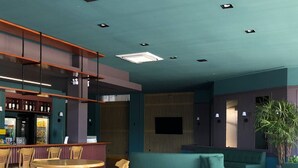 A modern interior with a bar area, seating, and a large plant. - Villa Premium Hotel (Erechim)
