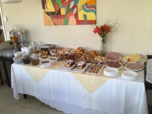 A buffet table with various food items and a painting on the wall. - Alamos del Mar (Valeria del Mar)