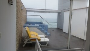 Un balcón con zona de estar y vista al mar.