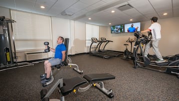 A gym with treadmills, a stationary bike, and a weight bench.