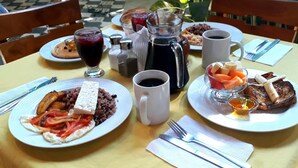 A table set with plates of food, a coffee pot, and a pitcher of juice. - Hotel La Polvora (Granada)