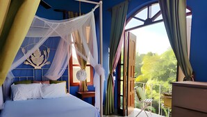 A bedroom with a bed, a nightstand, a window with curtains, and a balcony with a chair. - Hotel La Polvora (Granada)