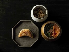 Un plato hexagonal con un pastel, un tazón de fideos y un tazón de especias mezcladas.